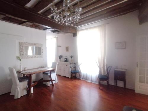 une salle à manger avec une table, des chaises et un lustre dans l'établissement Cœur de Paris Montorgueil - Heart of Paris - Charming super central apartment for your ideal Parisian days, à Paris