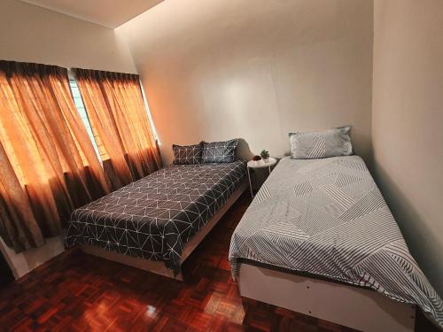 a bedroom with two beds and a window at A Humble Abode Homestay By irainbow in Ipoh