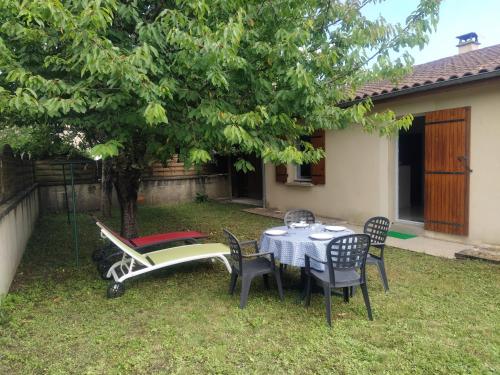 - une table, des chaises et un bateau dans la cour dans l'établissement L'Olivier Maison de village avec jardin au calme pour 6 pers, à Saint-Cyprien