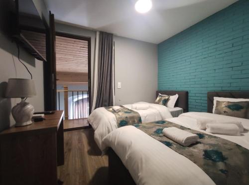 - une chambre avec 2 lits et un mur en briques bleues dans l'établissement tbilicity hotel, à Tbilissi