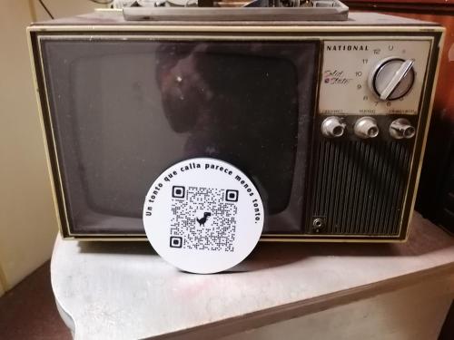 una vecchia radio seduta su un tavolo con un adesivo sopra di Hostal Palafox a Barbastro