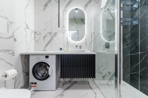 a bathroom with a washing machine and a mirror at Apartament Przy Plaży - Zielony Szmaragd by Perłowa Przystań Rent in Sianozety