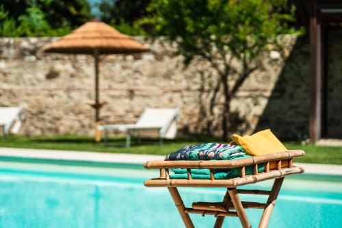 佛羅倫斯的住宿－羅浮匝諾住宿加早餐酒店，游泳池旁的一把椅子,上面有书和遮阳伞