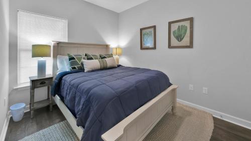 een slaapkamer met een bed met een blauwe deken bij Luna Sea - Is a short walk to the beach and close to Seaside in Santa Rosa Beach