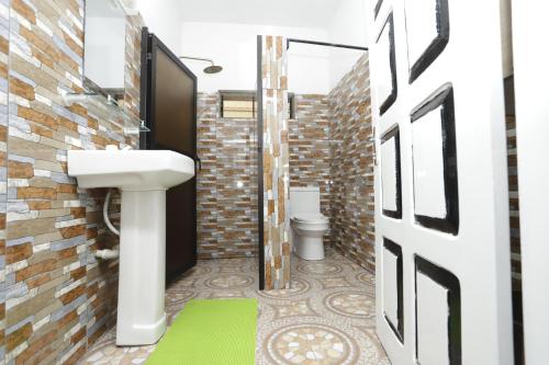 a bathroom with a sink and a toilet at Villa Flo Residence in Lomé