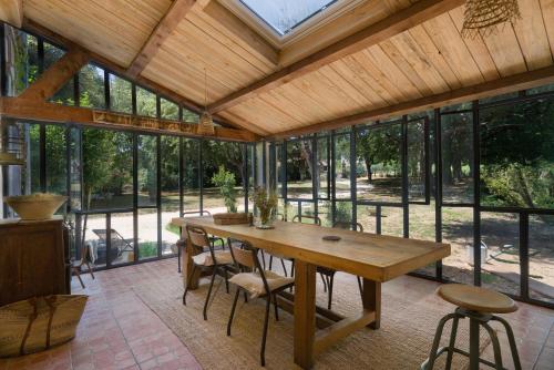 a large conservatory with a wooden table and chairs at B&B Maison Felisa in Sabran