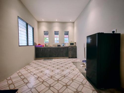 a kitchen with a black refrigerator in a room at A Humble Abode Homestay By irainbow in Ipoh