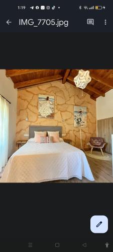 a bedroom with a bed and a stone wall at APARTAMENTOS TURISTICOS LAS CANDELAS in Puebla de Sanabria