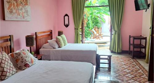 1 dormitorio con 2 camas y puerta a un patio en Hotel La Polvora en Granada