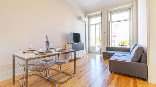 a living room with a table and a couch at Duque Flat - AC & Balcony by LovelyStay in Porto