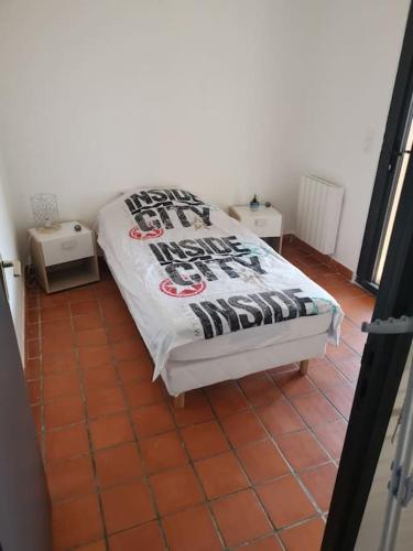 a bed sitting on a tiled floor in a room at Haut de villa rénovée en 2023 in Saint-Maime