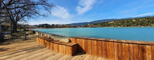 a wooden boardwalk next to a large body of water at Haut de villa rénovée en 2023 in Saint-Maime