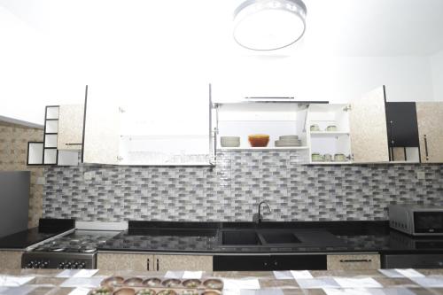 a kitchen with a sink and a stove top oven at Villa Flo Residence in Lomé
