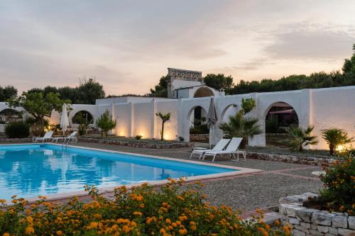 a villa with a swimming pool at dusk at Masseria Gorgognolo in Ostuni