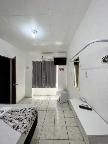 um quarto de hospital com uma cama e uma televisão em HOTEL AVENIDA em Belém