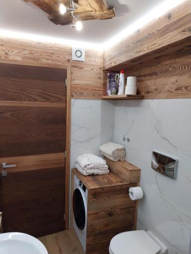 uma casa de banho com um WC e uma máquina de lavar roupa em Bertuzzi Luxury Chalet em Aprica