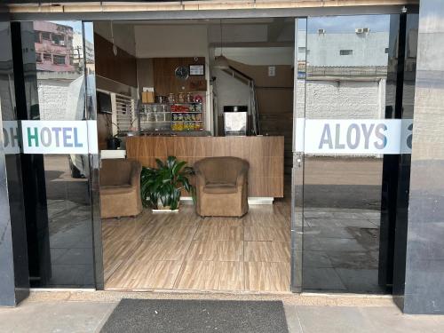 a glass door of a hotel with two chairs in it at Aloys Hotel in Cascavel