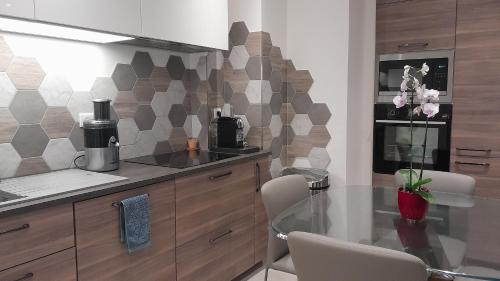 une cuisine avec une table en verre dans l'établissement Apt 2 Chambres - Direct Gare Part-Dieu, Lyon - Ascenseur & Wi-Fi Gratuit, à Lyon