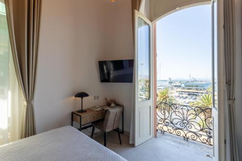 a bedroom with a bed and a desk and a balcony at Magnini Rooms in Cagliari