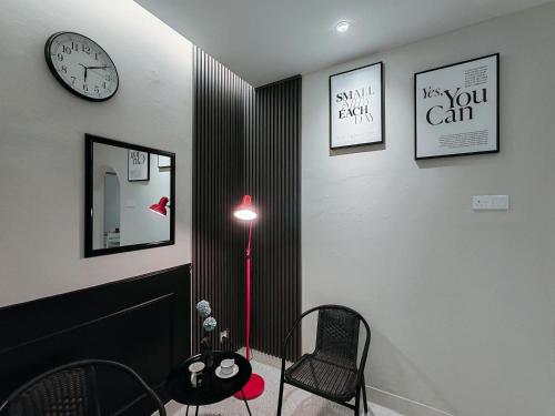 a room with a red floor lamp and a clock at A Humble Abode Homestay By irainbow in Ipoh