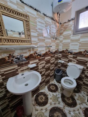 La salle de bains est pourvue d'un lavabo et de toilettes. dans l'établissement quiet home, à Siwa