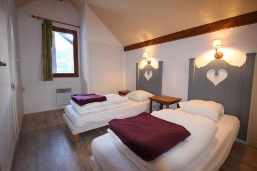 2 bedden in een kamer met paarse lakens bij DATCHA Joséphine Immobilier in Serre Chevalier
