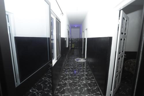 a hallway with black and white floors and doors at Villa Flo Residence in Lomé