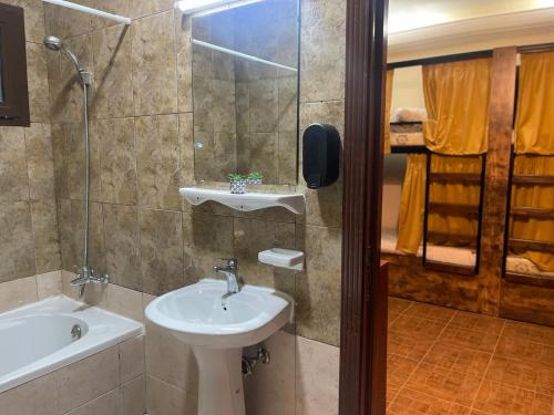 La salle de bains est pourvue d'un lavabo et d'une baignoire. dans l'établissement The Villa Hostel Abu Dhabi, à Abu Dhabi