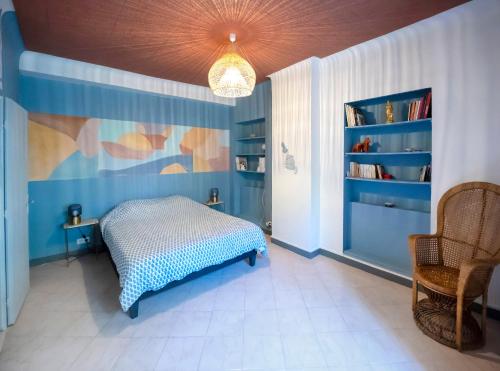 une chambre avec un lit et un mur bleu dans l'établissement Très bel appartement avec une jolie vue dans le quartier prisé de Vauban, à Marseille
