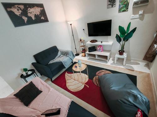 a living room with a couch and a tv at A Humble Abode Homestay By irainbow in Ipoh