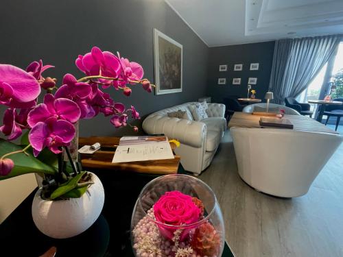a living room with pink flowers and a couch at Hotel Alfieri in Sirmione