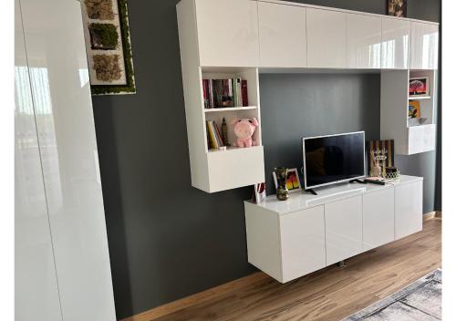 un soggiorno con mobile bianco e TV di Luxury ap 2 rooms - AB House a Lunca Cetăţuii
