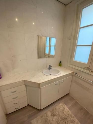 a white bathroom with a sink and a mirror at Passeig de Gracia Studio Loft in Barcelona