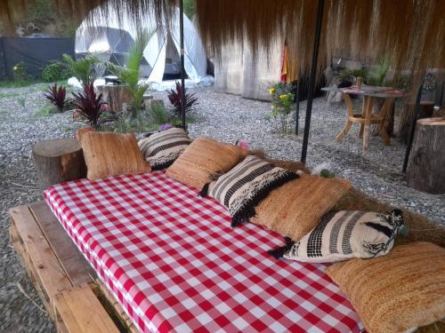 a couch with pillows sitting on top of it at IslaMontaña Glamping in Fómeque