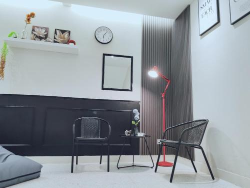 a room with two chairs and a table and a lamp at A Humble Abode Homestay By irainbow in Ipoh