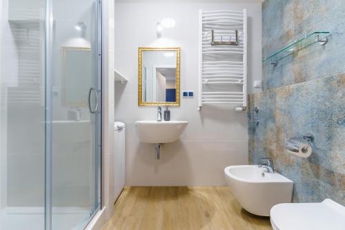 a white bathroom with a sink and a mirror at Apartament Kapitański z widokiem na morze 4 Piętro - by Perłowa Przystań Rent in Sianozety