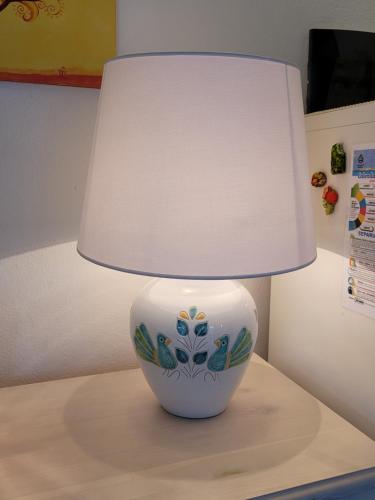 a white lamp sitting on top of a table at Villa La Pelosa Stintino in Stintino