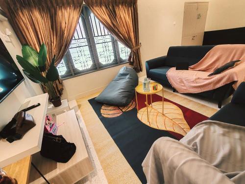 a living room with a couch and a table at A Humble Abode Homestay By irainbow in Ipoh