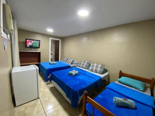 Habitación con 2 camas y TV de pantalla plana. en Lurviz Home Suítes, en Cabo Frío