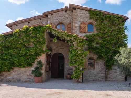 - une ancienne maison en pierre avec du lierre dans l'établissement Beautiful villa in San Giovanni del Pantano with pool, à San Giovanni del Pantano