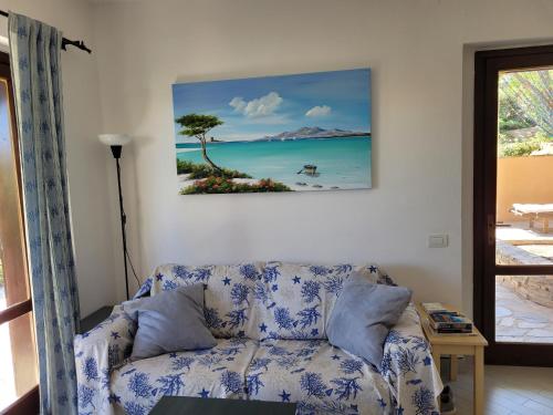 un soggiorno con divano e un dipinto sul muro di Villa La Pelosa Stintino a Stintino