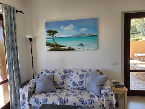 a living room with a couch and a painting on the wall at Villa La Pelosa Stintino in Stintino