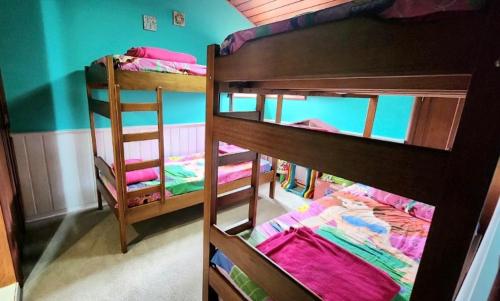 two bunk beds in a room with a ladder at Apartamento Duplex Alto do Capivari in Campos do Jordão