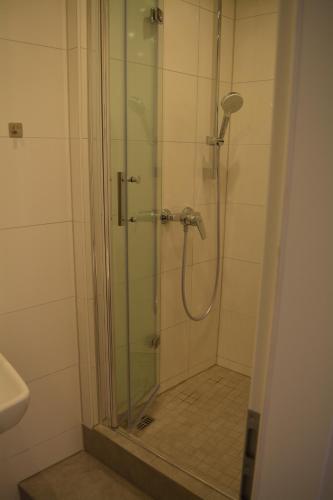 a bathroom with a shower with a glass door at Hotel BaWü in Stuttgart