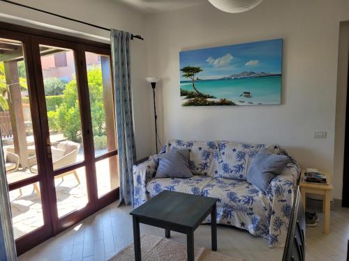 uma sala de estar com um sofá e vista para o oceano em Villa La Pelosa Stintino em Stintino