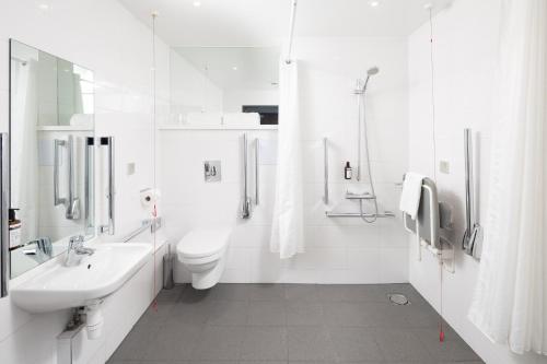 a white bathroom with a sink and a toilet at Point A Hotel London Kings Cross – St Pancras in London