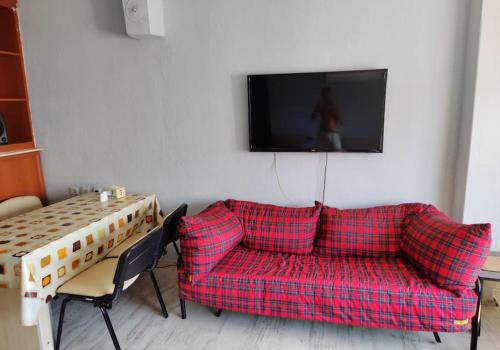 BurunabatにあるYemyeşil tertemiz havalı köy eviのリビングルーム(赤いソファ、テーブル付)