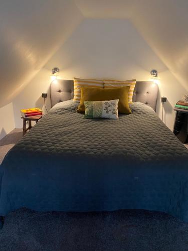 a bedroom with a large bed with yellow pillows at Holmsminde in Viborg