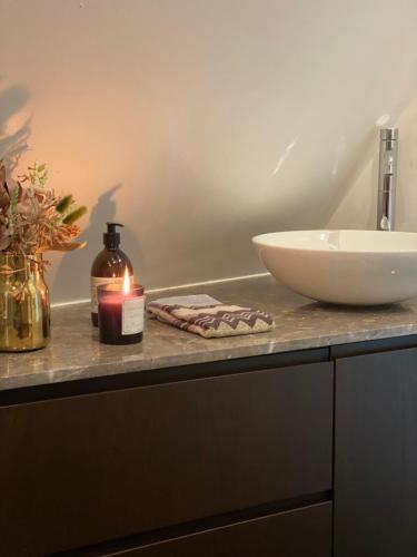 a bathroom with a sink and a candle on a counter at Holmsminde in Viborg