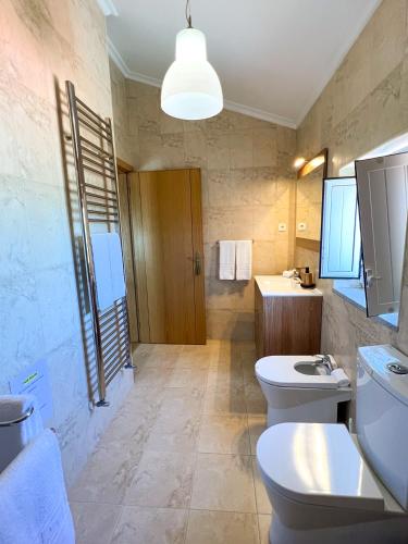 a bathroom with two toilets and a sink at Quinta das Covas - Trancoso in Trancoso
